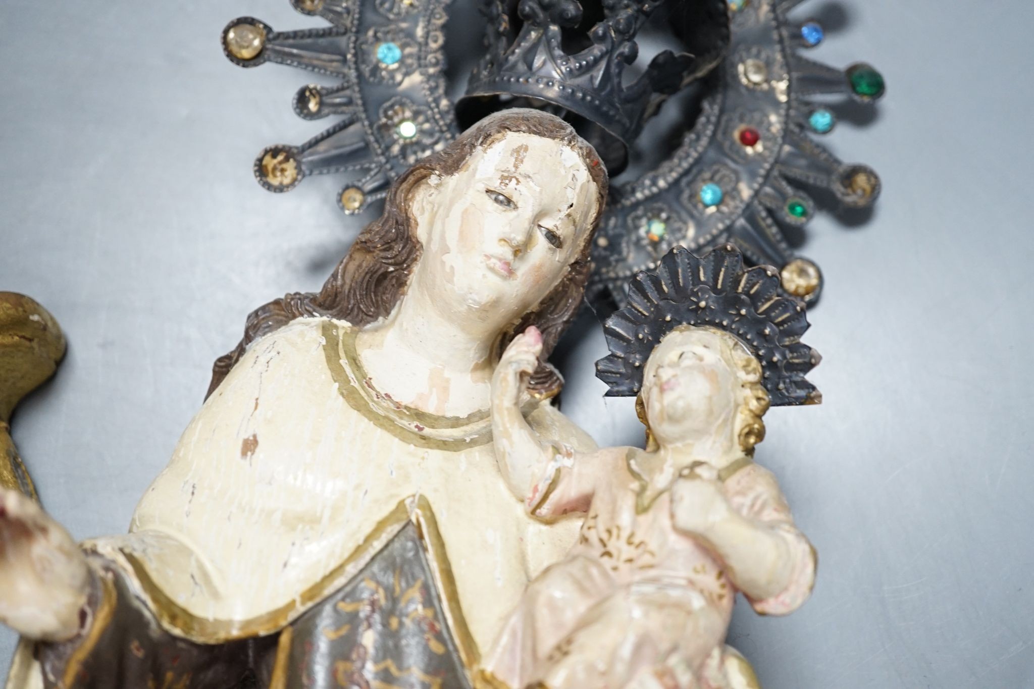 An ornate South American Madonna and child with a metal crown and halo, standing on a carved bracket, 39cm